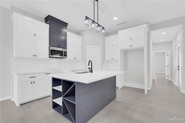 910 Azalea St, Mission, TX 78574 - kitchen featuring stainless steel microwave, open shelves, white cabinetry, hanging light fixtures, and recessed lighting