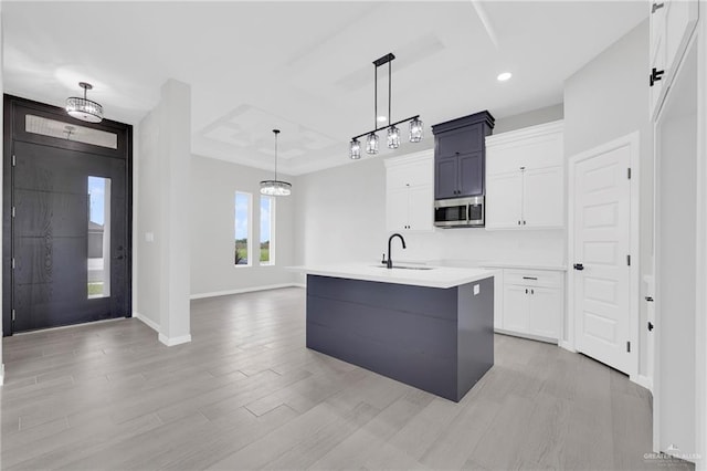 910 Azalea St, Mission, TX 78574 - kitchen featuring stainless steel microwave, white cabinets, light wood-type flooring, pendant lighting, and recessed lighting