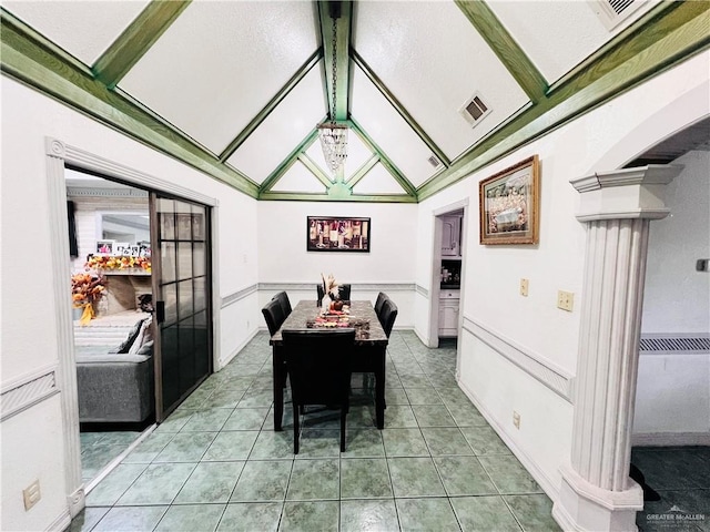 tiled dining area featuring lofted ceiling with beams and ornate columns