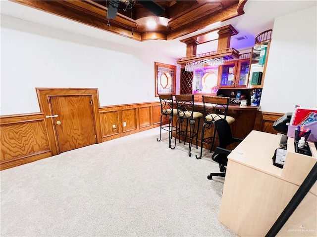 carpeted office space featuring beamed ceiling and bar