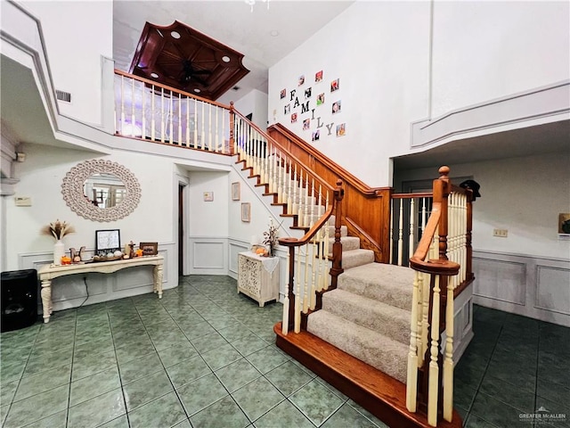 stairs with tile patterned flooring and a high ceiling