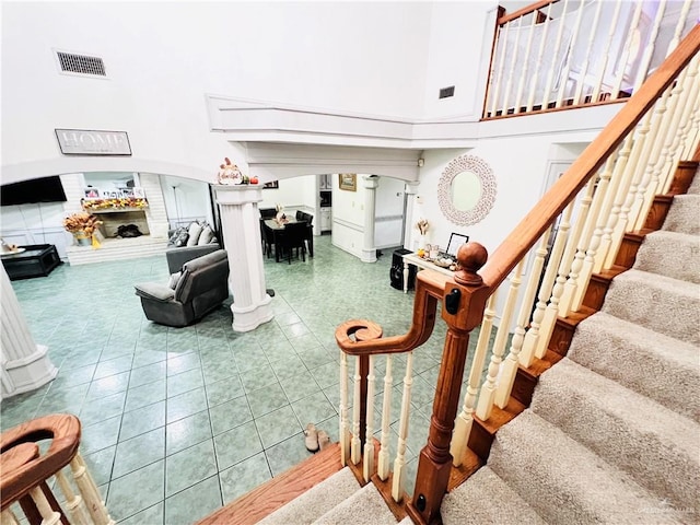 staircase featuring tile patterned flooring and a towering ceiling