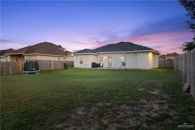 705 New Orleans Cir, Pharr, TX 78577 - back of house featuring a trampoline, stucco siding, and a patio