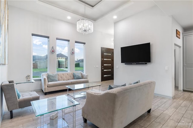 705 New Orleans Cir, Pharr, TX 78577 - living room featuring a chandelier, a towering ceiling, a tray ceiling, recessed lighting, and light wood-type flooring