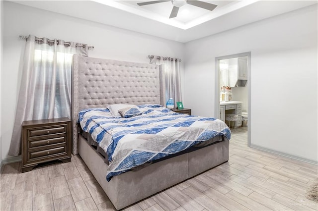 705 New Orleans Cir, Pharr, TX 78577 - bedroom with light wood-style flooring, a tray ceiling, ensuite bath, and ceiling fan