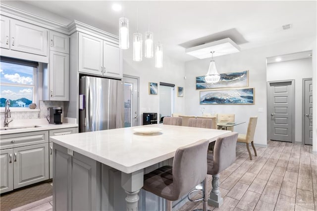 705 New Orleans Cir, Pharr, TX 78577 - kitchen featuring freestanding refrigerator, a sink, light countertops, gray cabinetry, and a center island