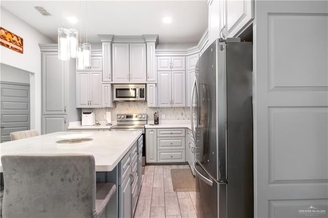 705 New Orleans Cir, Pharr, TX 78577 - kitchen featuring stainless steel appliances, gray cabinets, light countertops, backsplash, and pendant lighting