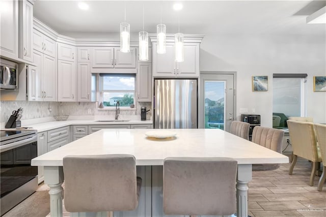 705 New Orleans Cir, Pharr, TX 78577 - kitchen with appliances with stainless steel finishes, a sink, a breakfast bar area, light countertops, and backsplash