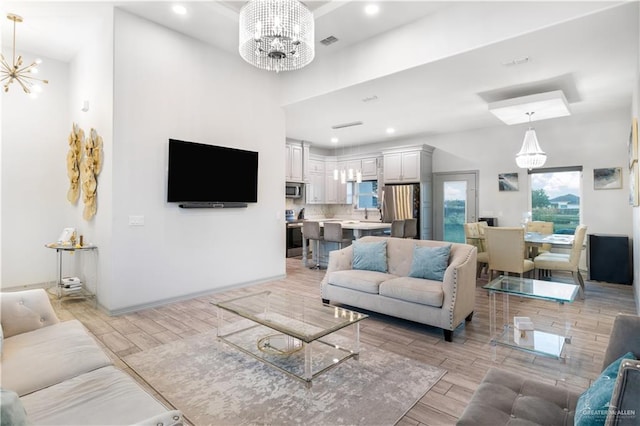 705 New Orleans Cir, Pharr, TX 78577 - living room featuring a chandelier, light wood-type flooring, a high ceiling, recessed lighting, and baseboards