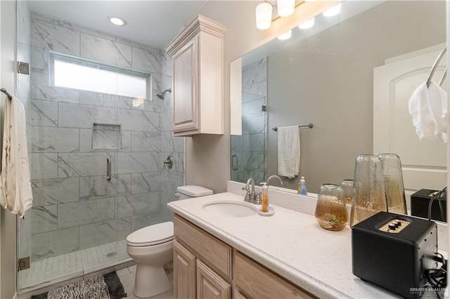 full bathroom featuring toilet, a stall shower, and vanity