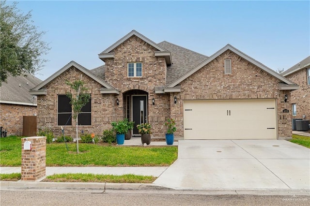 view of front facade with central AC unit, a garage, brick siding, concrete driveway, and roof with shingles