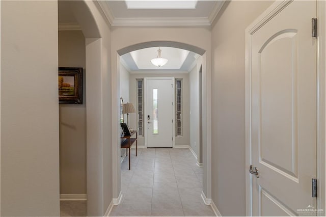 entryway with arched walkways, light tile patterned flooring, crown molding, and baseboards