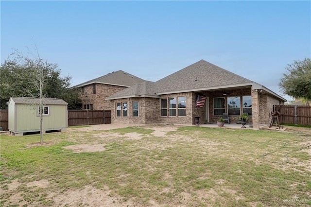 back of property featuring an outbuilding, a patio area, a fenced backyard, and brick siding