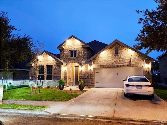 view of front of home with a garage, concrete driveway, brick siding, and a front yard