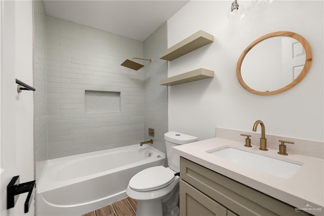 full bathroom featuring tiled shower / bath, vanity, and toilet