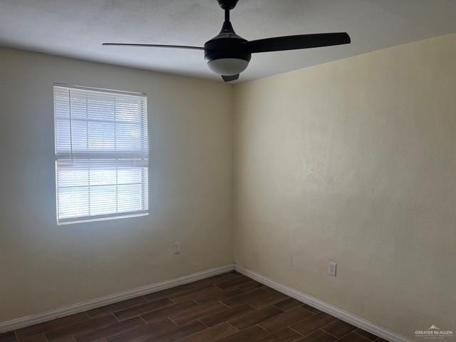 empty room featuring ceiling fan, baseboards, and wood tiled floor