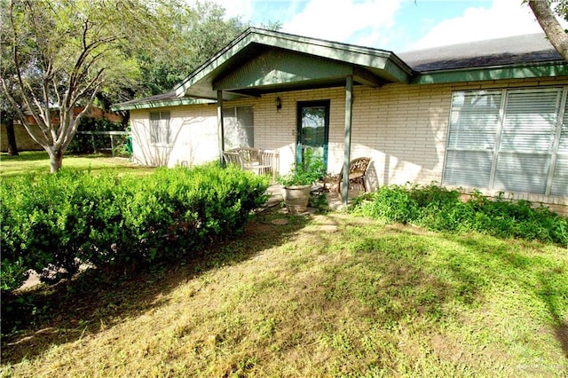 view of exterior entry with a yard