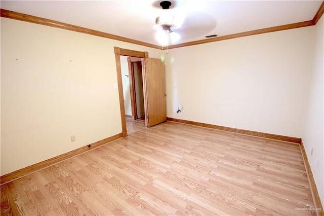 empty room with ornamental molding and light wood-type flooring