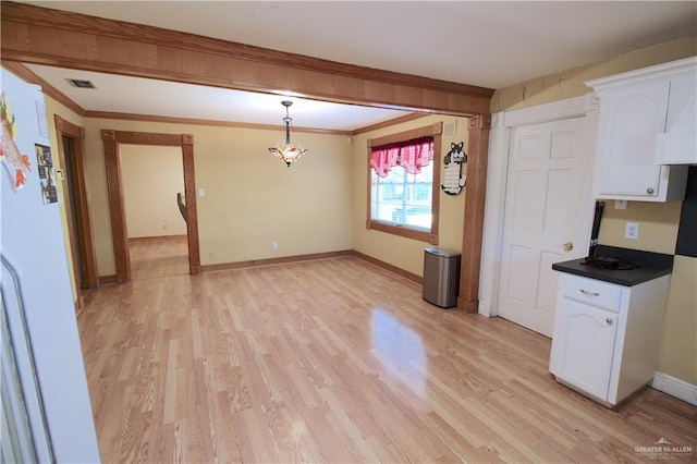 kitchen with white cabinets, light wood-type flooring, decorative light fixtures, and ornamental molding