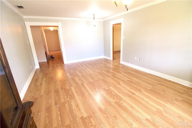 spare room with light wood-type flooring and crown molding