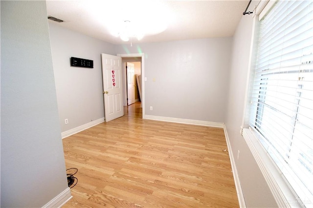 spare room with a wealth of natural light and light hardwood / wood-style flooring