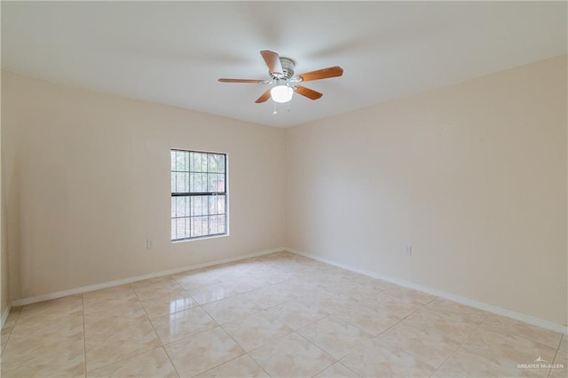 empty room featuring baseboards, a ceiling fan, and light tile patterned flooring