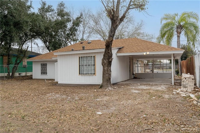 exterior space featuring a shingled roof and fence