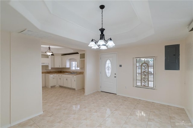 foyer featuring light tile patterned floors, a notable chandelier, baseboards, electric panel, and a raised ceiling