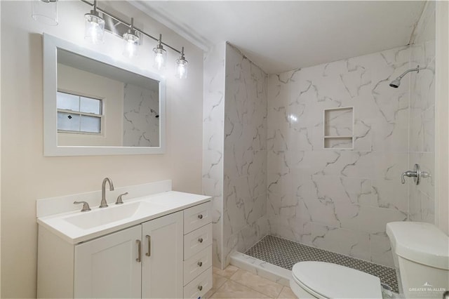 bathroom with toilet, a stall shower, and vanity