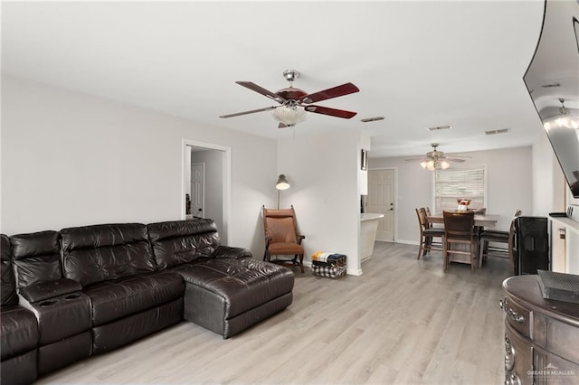 living room with light hardwood / wood-style flooring and ceiling fan