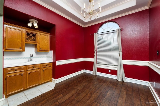 2106 Quail Ln, Mission, TX 78572 - kitchen with a chandelier, crown molding, a sink, light countertops, and brown cabinets
