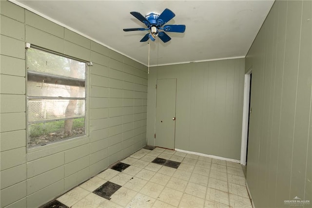 empty room featuring ceiling fan, ornamental molding, and light floors