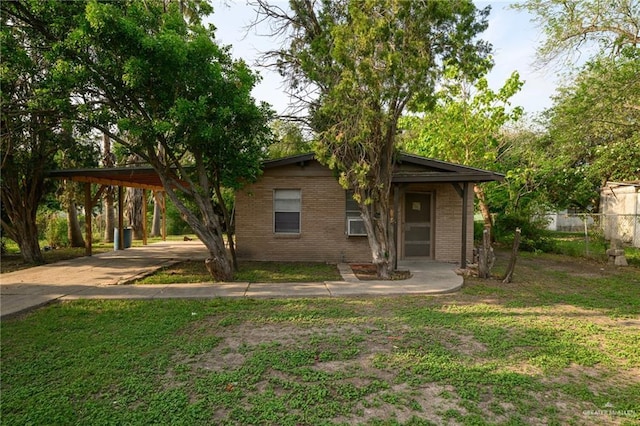 view of front of house with concrete driveway, brick siding, fence, and an attached carport