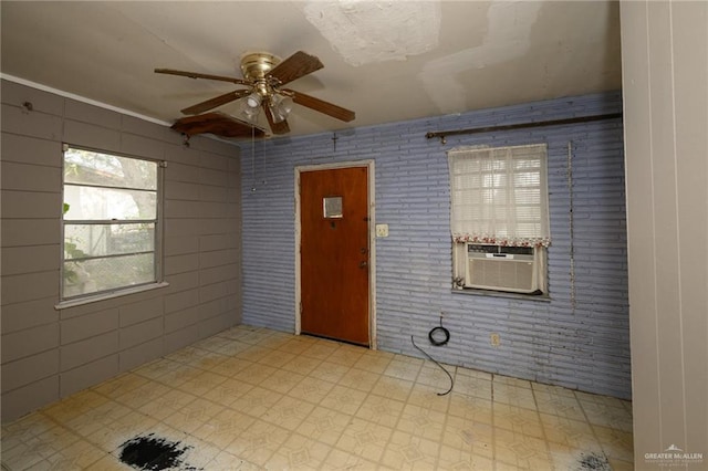 unfurnished room featuring cooling unit, brick wall, ceiling fan, and tile patterned floors