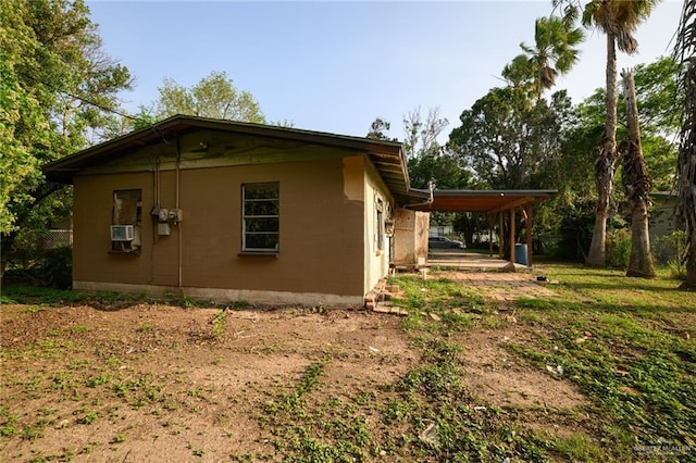 view of side of home with a carport and concrete block siding