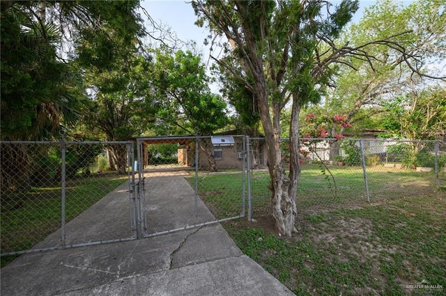 view of gate featuring a lawn and fence