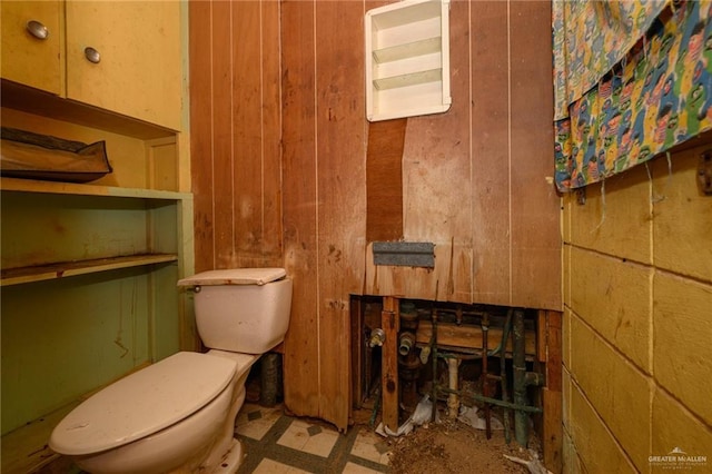 half bath with wooden walls and toilet