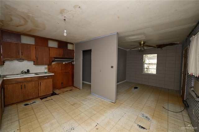 kitchen with light floors, brown cabinetry, light countertops, and ceiling fan