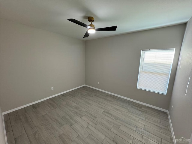 spare room with ceiling fan and light wood-type flooring