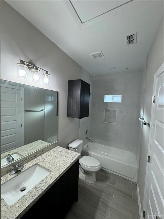 full bathroom featuring vanity, toilet, and tiled shower / bath combo