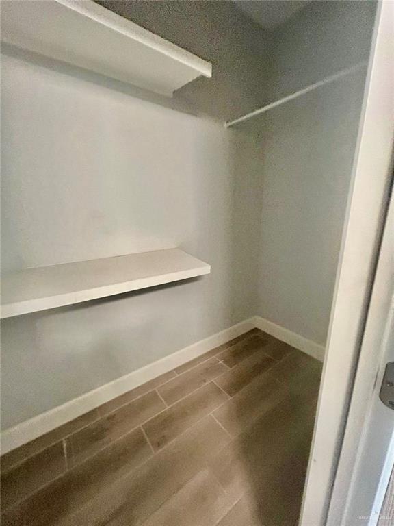 walk in closet with hardwood / wood-style flooring