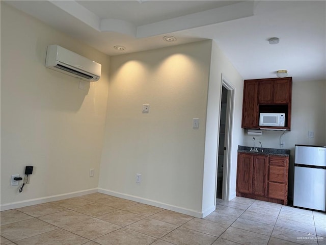 kitchen featuring light tile patterned floors, stainless steel refrigerator, and a wall mounted AC