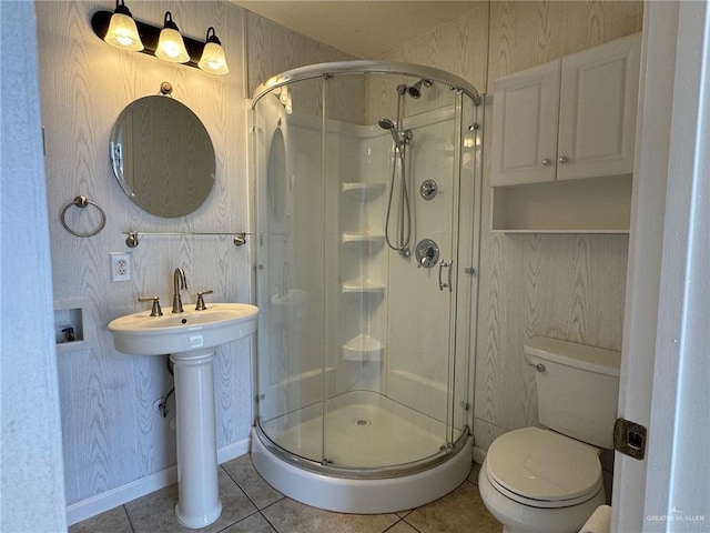 bathroom with toilet, sink, tile patterned flooring, and walk in shower