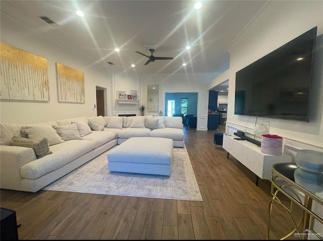 living room featuring dark wood-style flooring, recessed lighting, visible vents, ornamental molding, and a ceiling fan