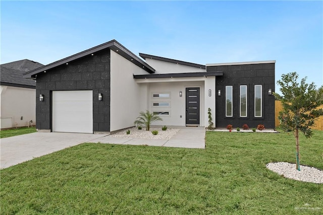 contemporary house with a front yard, concrete driveway, an attached garage, and stucco siding