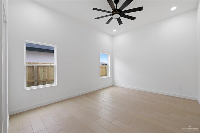 spare room featuring light wood-style floors, recessed lighting, baseboards, and a ceiling fan