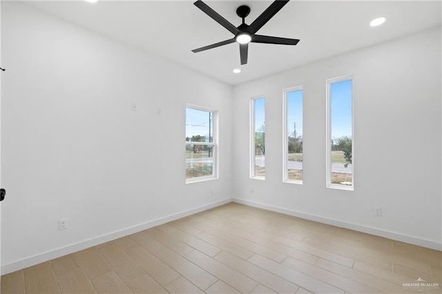 empty room with light wood-type flooring, baseboards, a ceiling fan, and recessed lighting