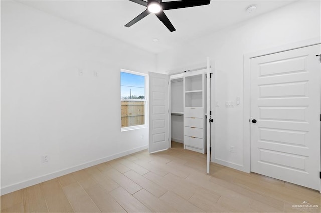 unfurnished bedroom featuring light wood-type flooring, two closets, a ceiling fan, and baseboards