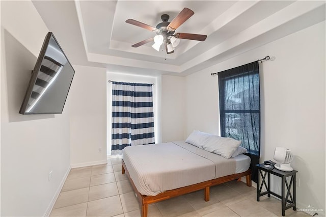 tiled bedroom featuring a raised ceiling and ceiling fan