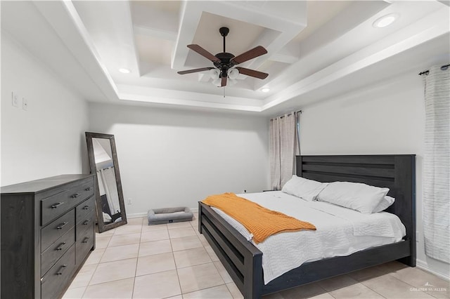 tiled bedroom with a tray ceiling and ceiling fan